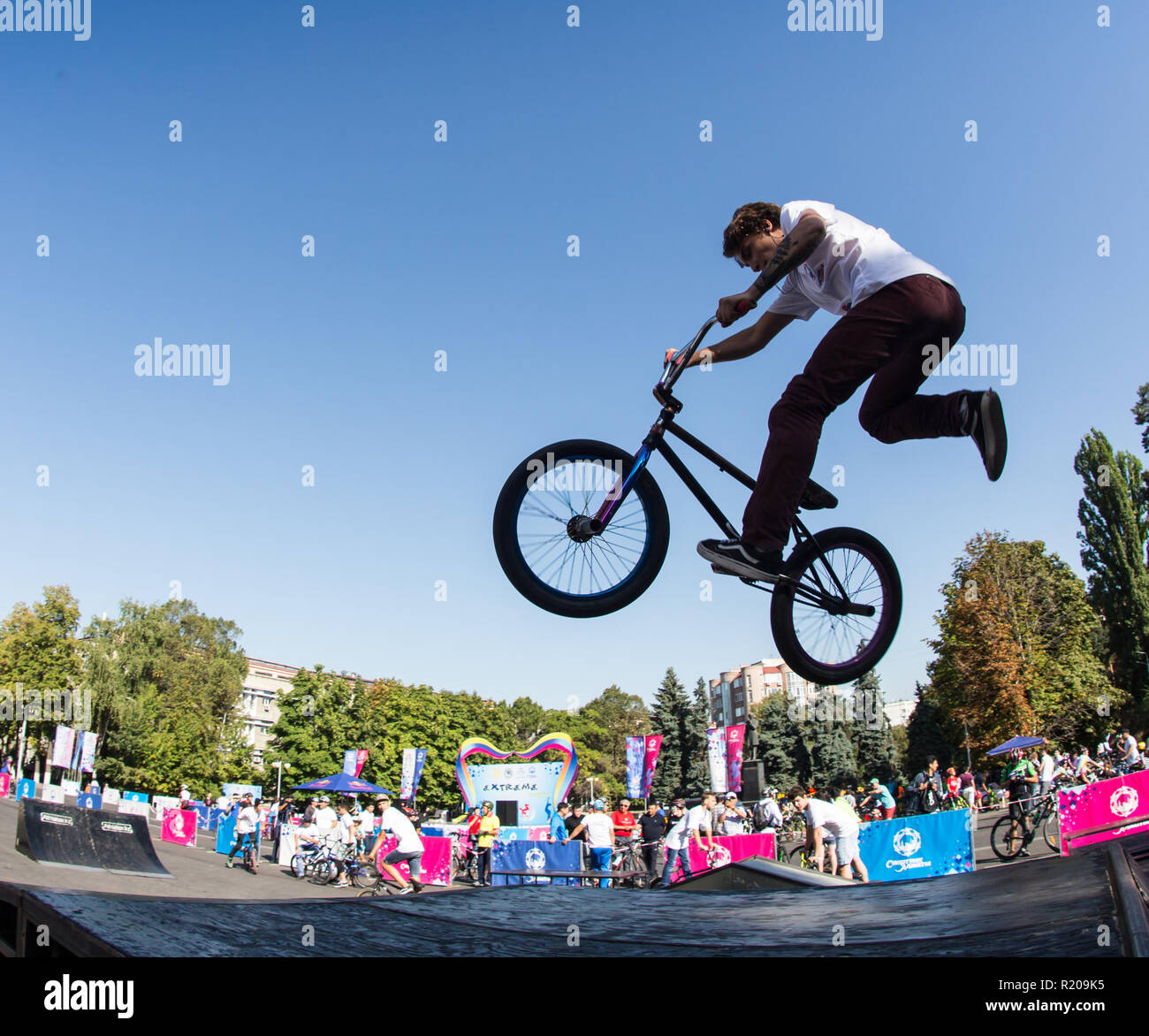 KAZAKHSTAN ALMATY - AUGUST 28, 2016: Urban extreme competition, where the city athletes compete in the disciplines: skateboard, roller skates, BMX. Bmx stunt performed at the top of a mini ramp on a skatepark. Stock Photo