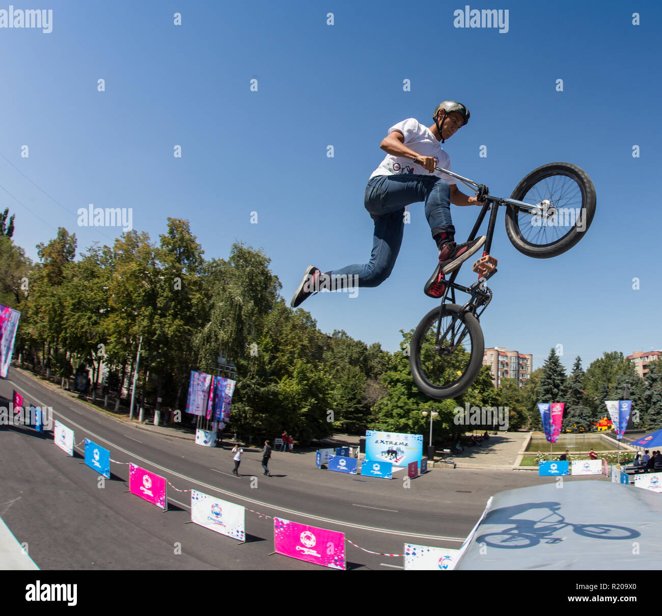 KAZAKHSTAN ALMATY - AUGUST 28, 2016: Urban extreme competition, where the city athletes compete in the disciplines: skateboard, roller skates, BMX. Bmx stunt performed at the top of a mini ramp on a skatepark. Stock Photo