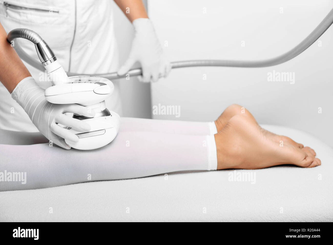 beautician doing lpg massage against cellulite on female leg Stock Photo