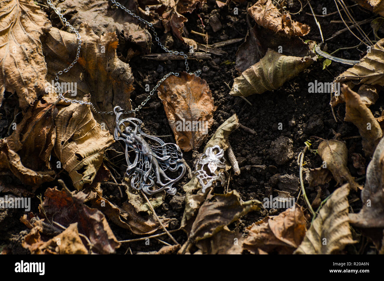 Art nouveau jewelry outside on the ground with autumn leaves - jugendstil or secession style accessories Stock Photo