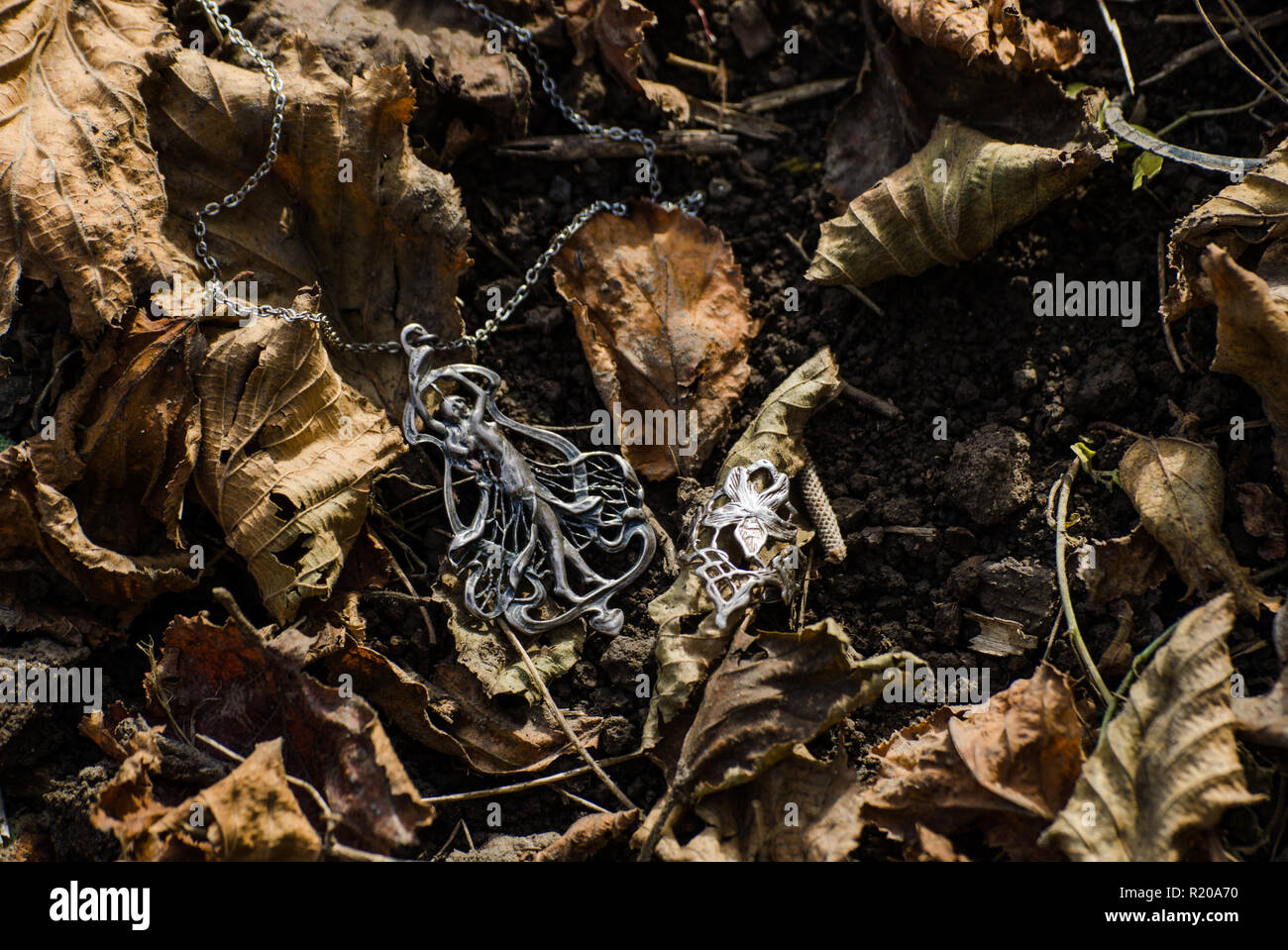 Art nouveau jewelry outside on the ground with autumn leaves - jugendstil or secession style accessories Stock Photo