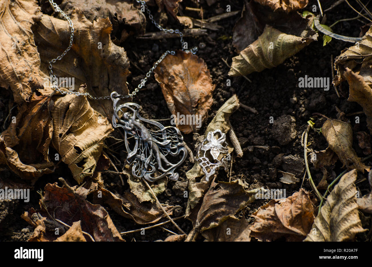 Art nouveau jewelry outside on the ground with autumn leaves - jugendstil or secession style accessories Stock Photo