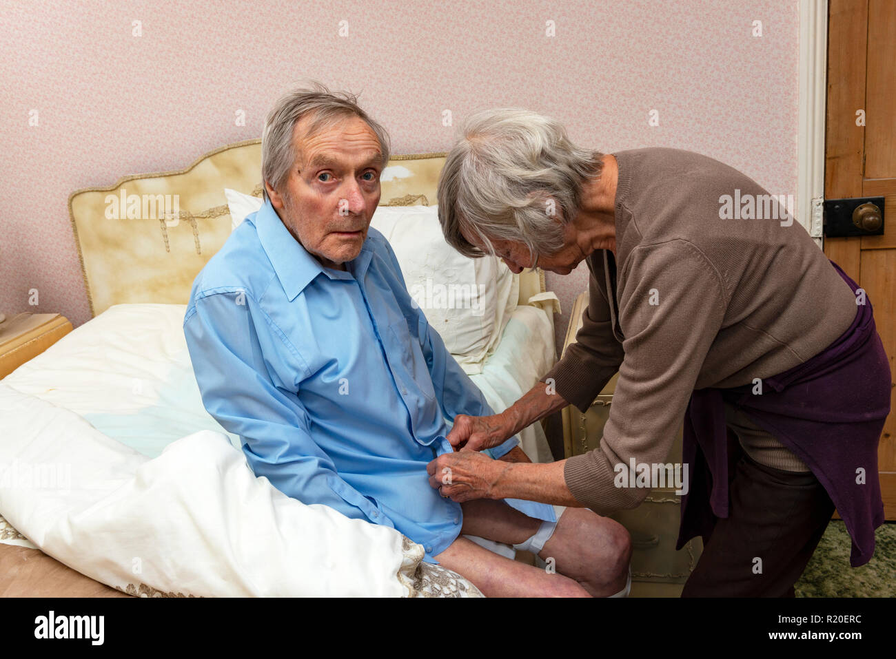 Sister helping her elderly brother to get dressed Stock Photo Alamy