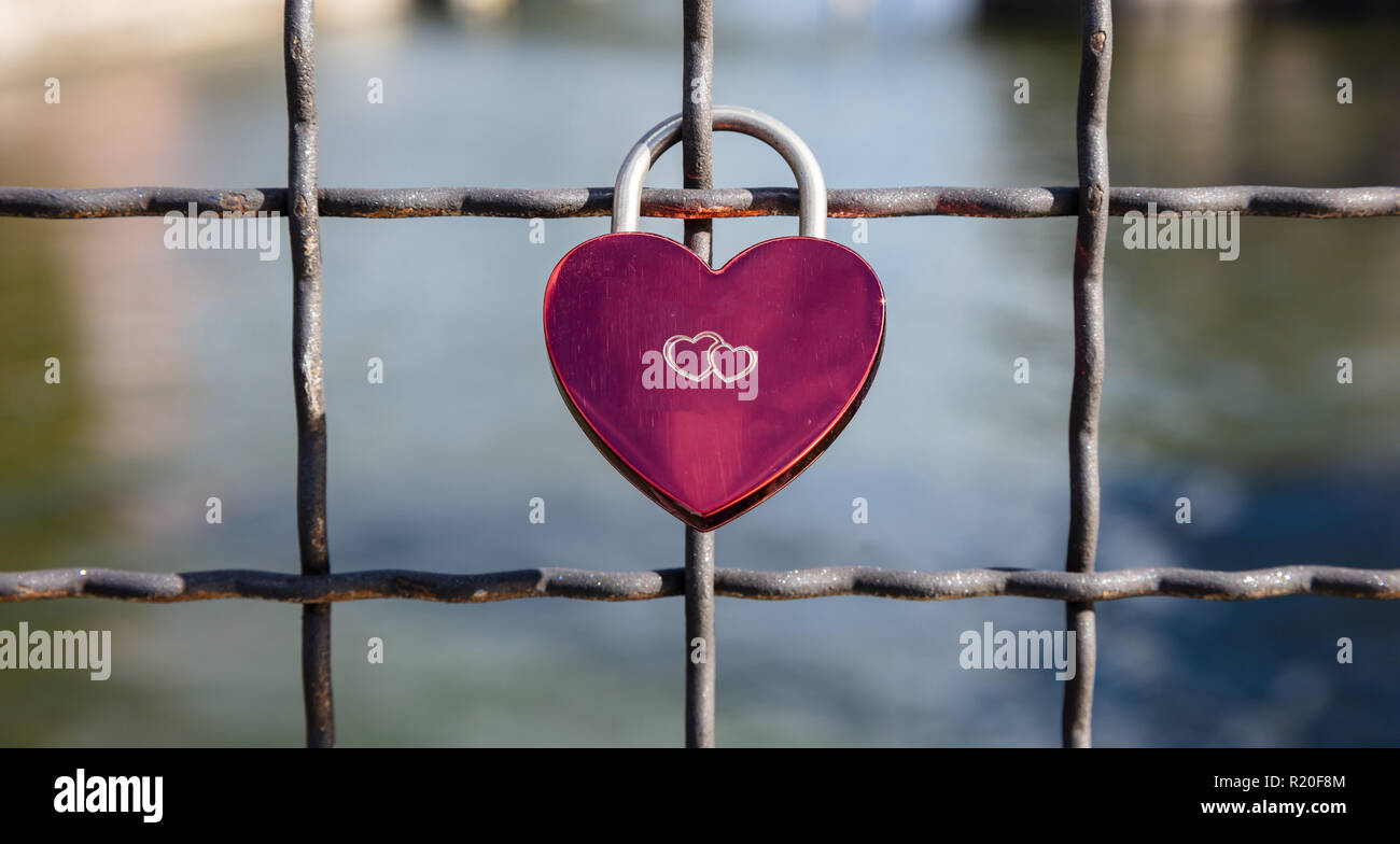 Lock your love for ever. Pink heart shaped padlock on a link fence ...