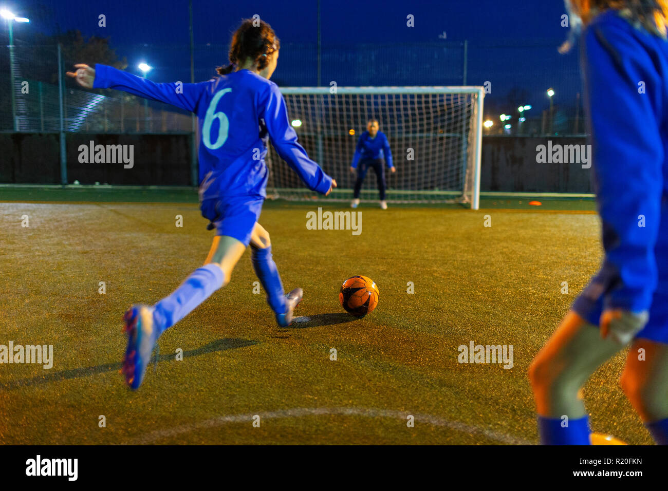 Girl soccer player kicking ball toward goal Stock Photo - Alamy