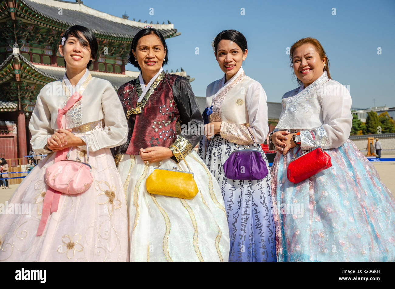 Group of friends pose for a picture at Gyeongbokgung Palace in Seoul, dressed in traditional Korean dress, the hanbok. Stock Photo
