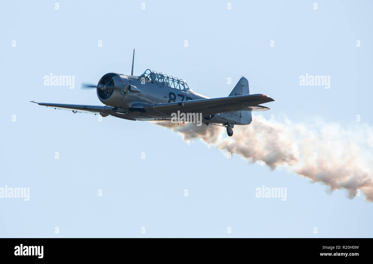MONROE, NC (USA) - November 10, 2018: A T-6 Texan aircraft in flight with a contrail at the Warbirds Over Monroe Air Show. Stock Photo