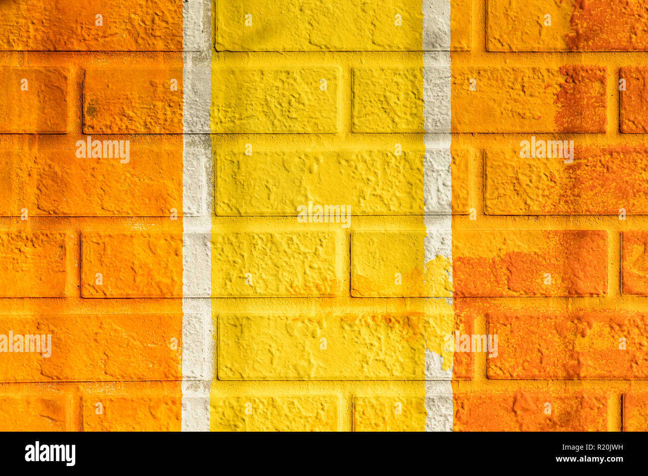 Bricks surface of wall, painted vertical lines in orange and yellow colors. Graphic grunge