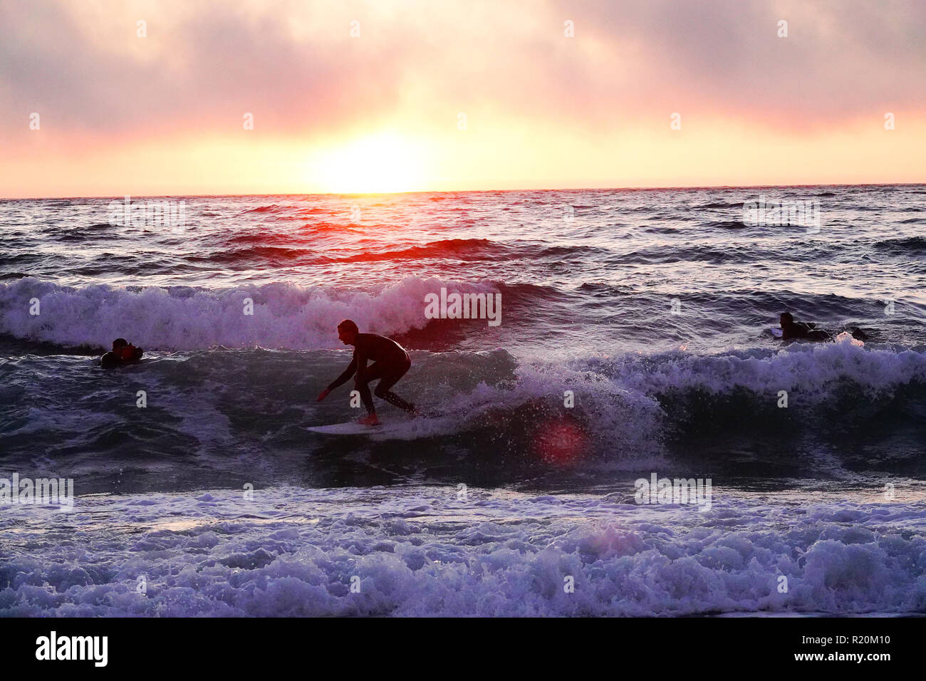 A silhouette of a surfer at sunset Stock Photo - Alamy