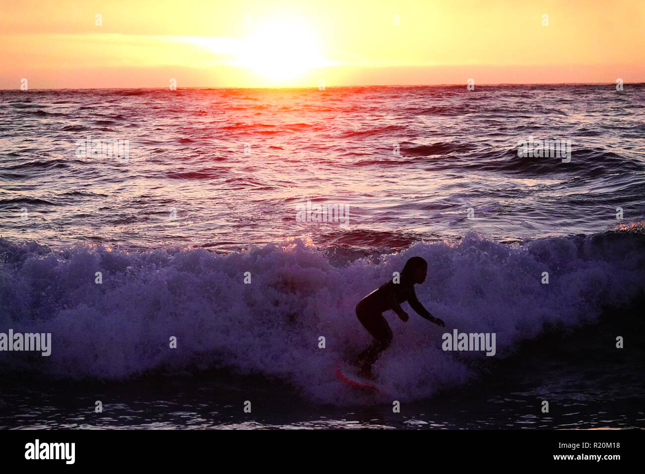 A silhouette of a surfer at sunset Stock Photo - Alamy