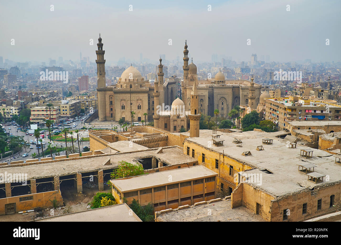 The white evening fog covers residential quarters of Islamic Cairo, only the huge buildings of Al Rifai' and Sultan Hassan mosques with tall minarets  Stock Photo