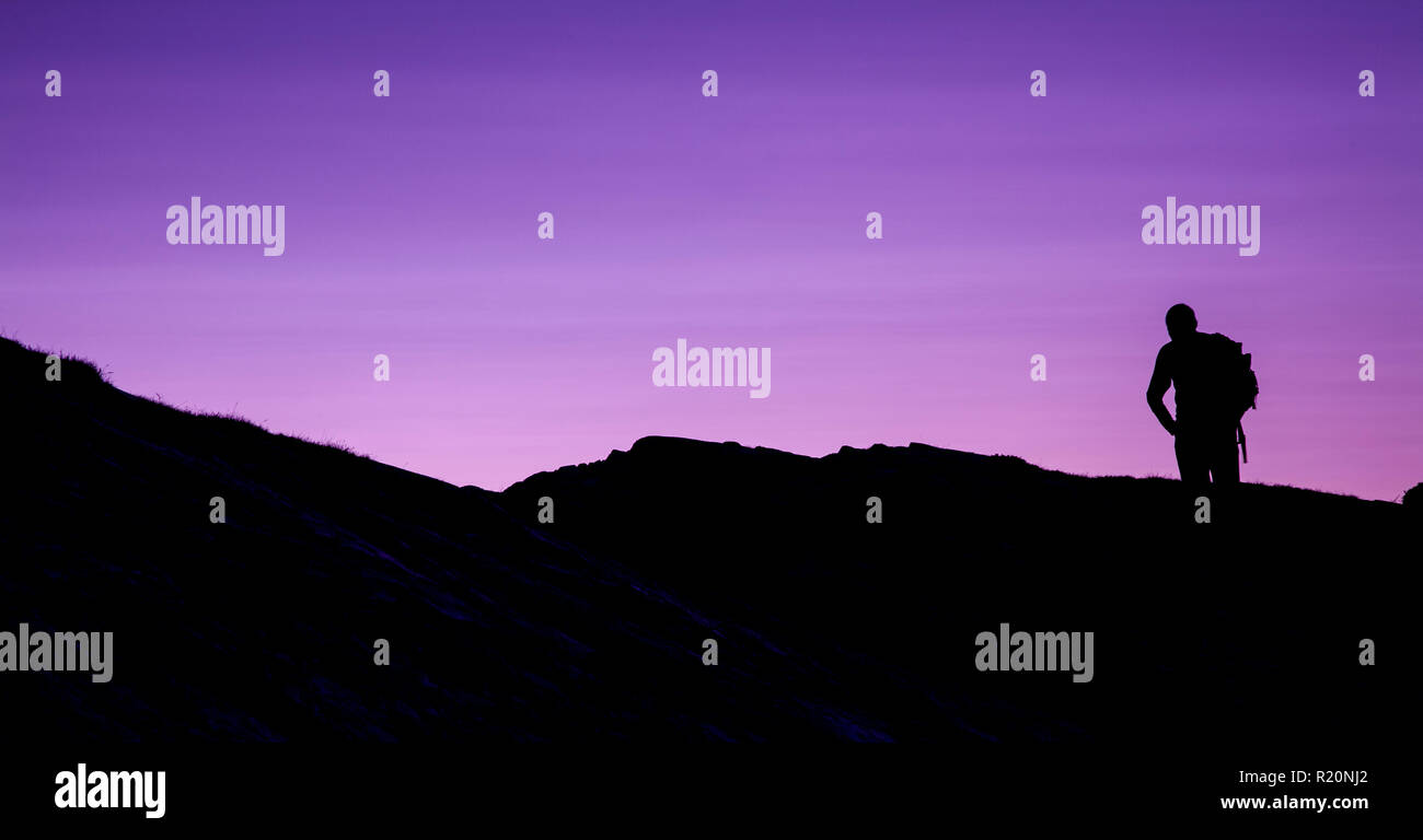 Silhouette of a hiker at dusk, Anglesey, North Wales Stock Photo