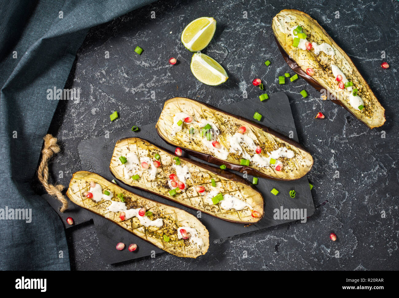 grilled eggplants with garlic yogurt sauce and pomegranate on black