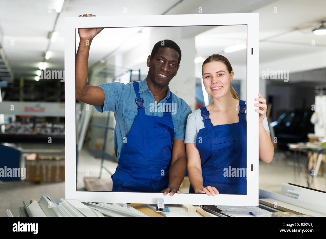 Two masters are working with window frame in the window workshop. Stock Photo