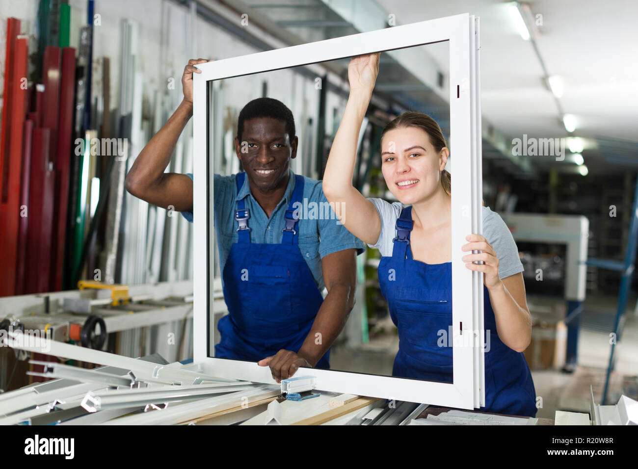 Two masters are working with window frame in the window workshop. Stock Photo