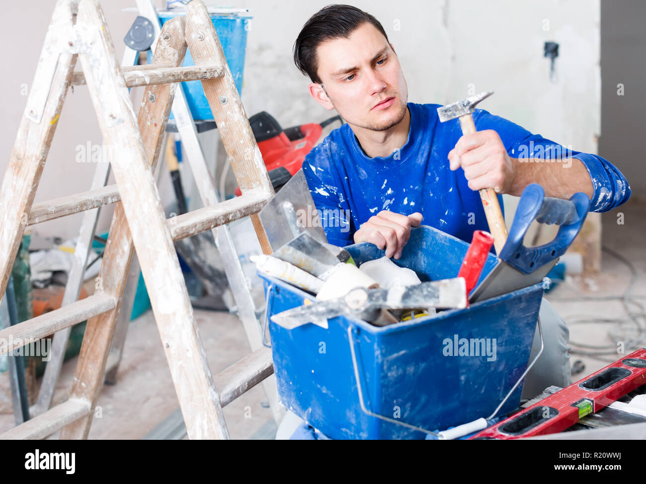 concentrated builder handyman choosing necessary tool in toolbox Stock Photo