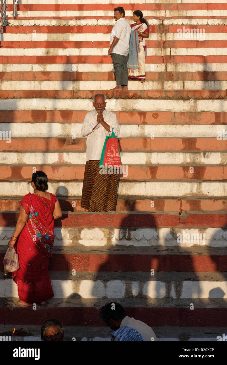 A Hindu worshiper prays on the steps on the banks of the Ganges river in Varanasi, India. Stock Photo