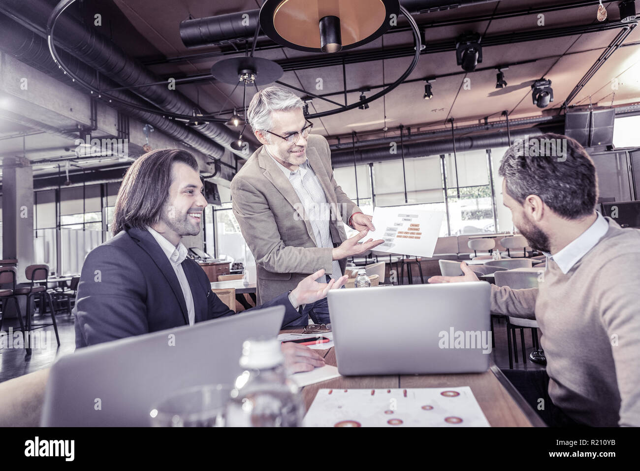 Joyful male person demonstrating his project work Stock Photo - Alamy