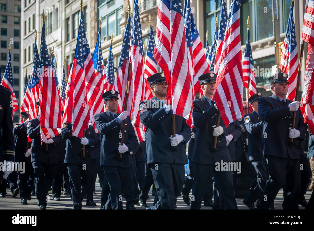 Members of the FDNY carry American flags on Fifth Avenue in New York during the Veterans Day Parade on Sunday, November 11, 2018.  Originally knows as Armistice Day, this year the holiday commemorates the 100th anniversary of the end of World War I. On the eleventh hour of the eleventh day of the eleventh month the guns fell silent in 1918 marking the end of World War I.  The holiday has been expanded to include all American soldiers from all wars. (Â© Richard B. Levine) Stock Photo
