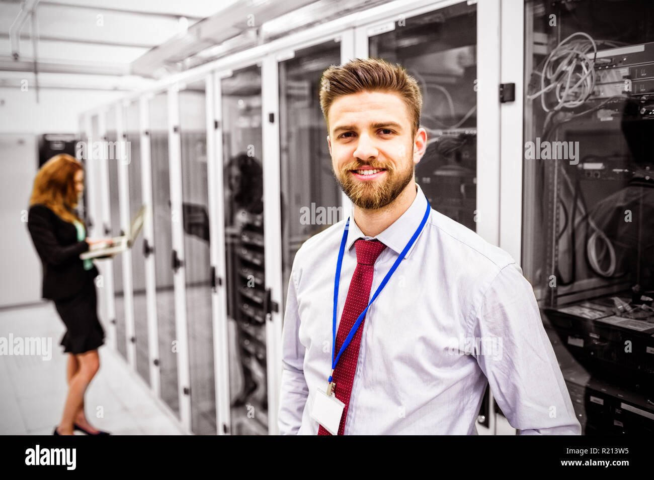 Smiling technician standing in a server room Stock Photo
