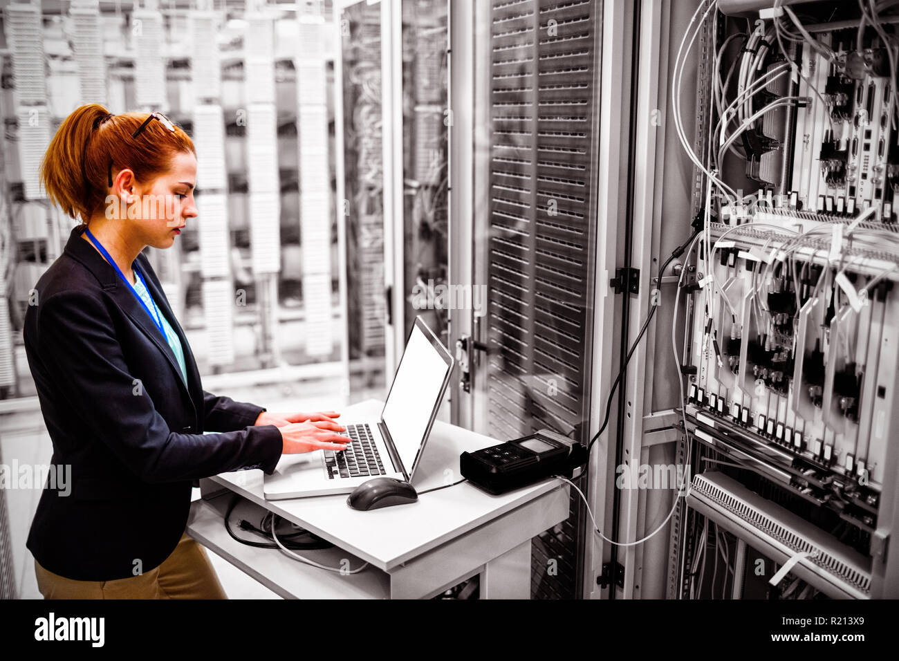 Technician using laptop while analyzing server Stock Photo