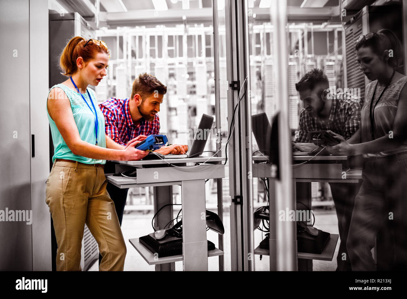 Technicians using laptop while analyzing server Stock Photo