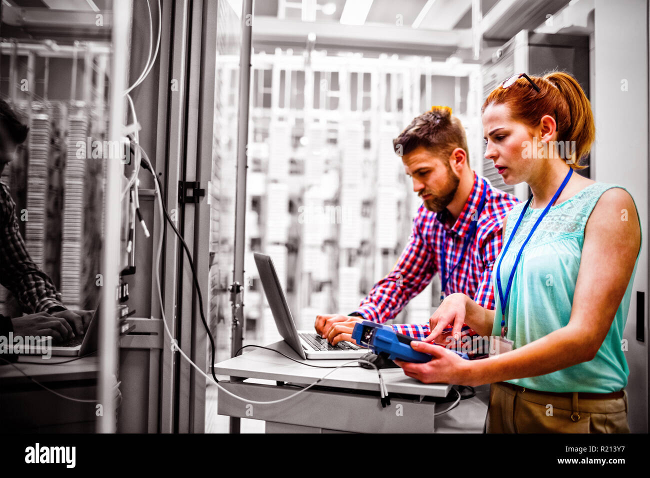 Technicians using laptop while analyzing server Stock Photo