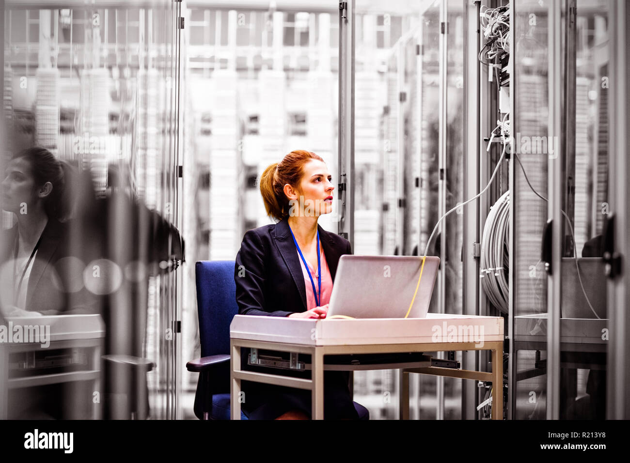 Technician using laptop while analyzing server Stock Photo