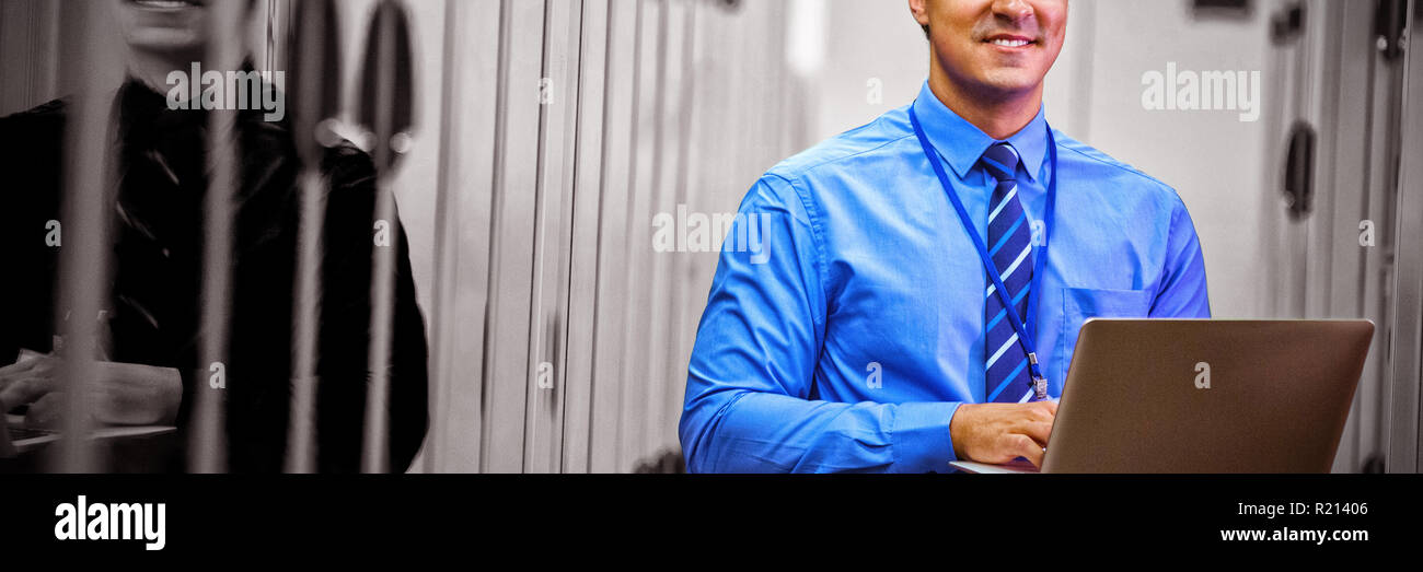 Portrait of technician using laptop while analyzing server Stock Photo