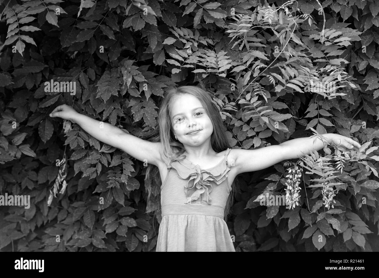 Child in summer dress pose with open hands, fashion. Small girl with long hair on natural landscape, beauty. Beauty fashion, hairstyle. Stock Photo