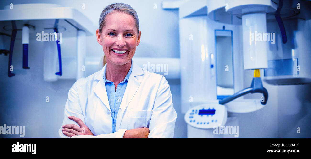 Portrait of female dentist smiling with arms crossed Stock Photo