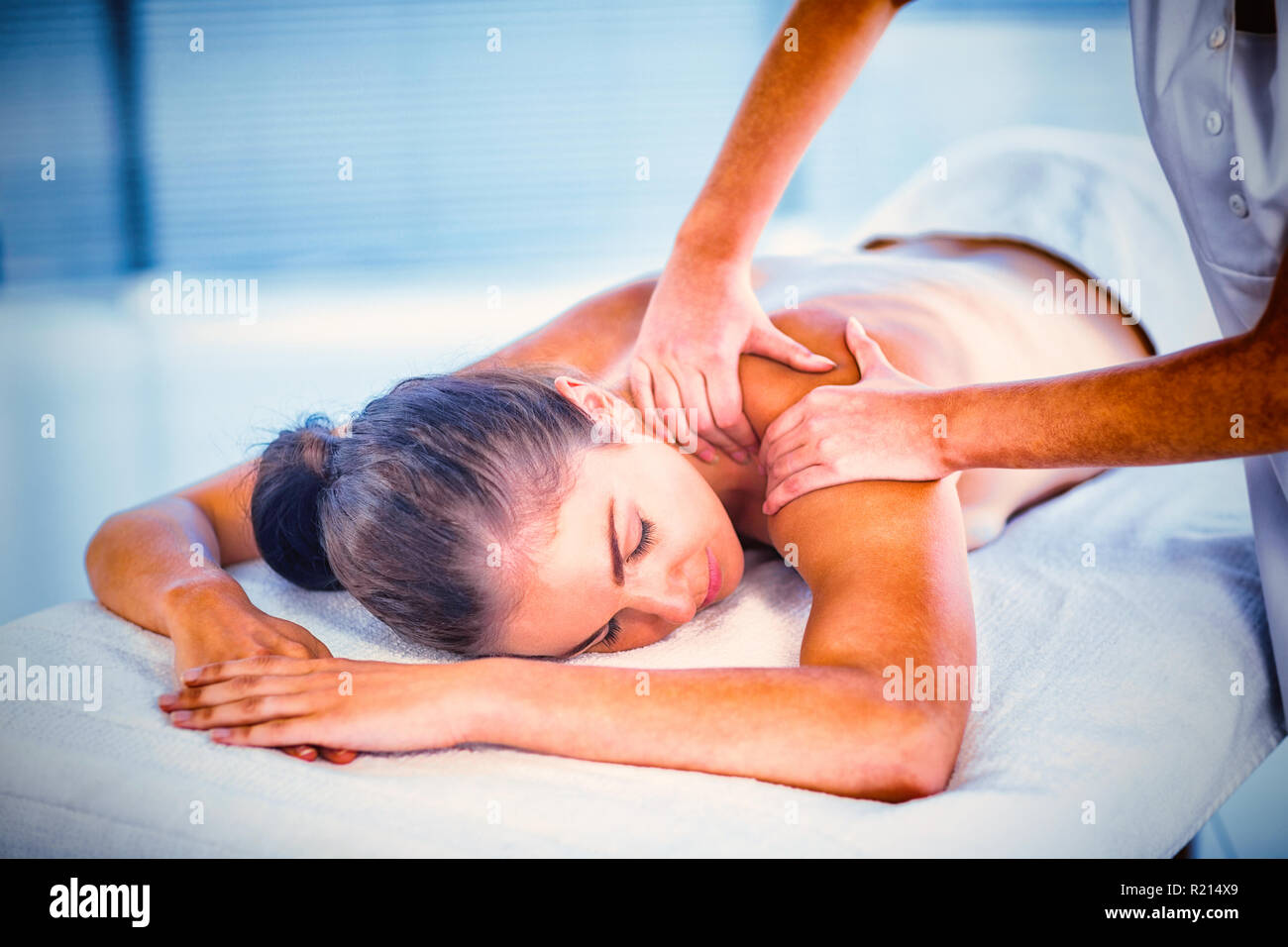 Relaxed naked woman receiving back massage Stock Photo