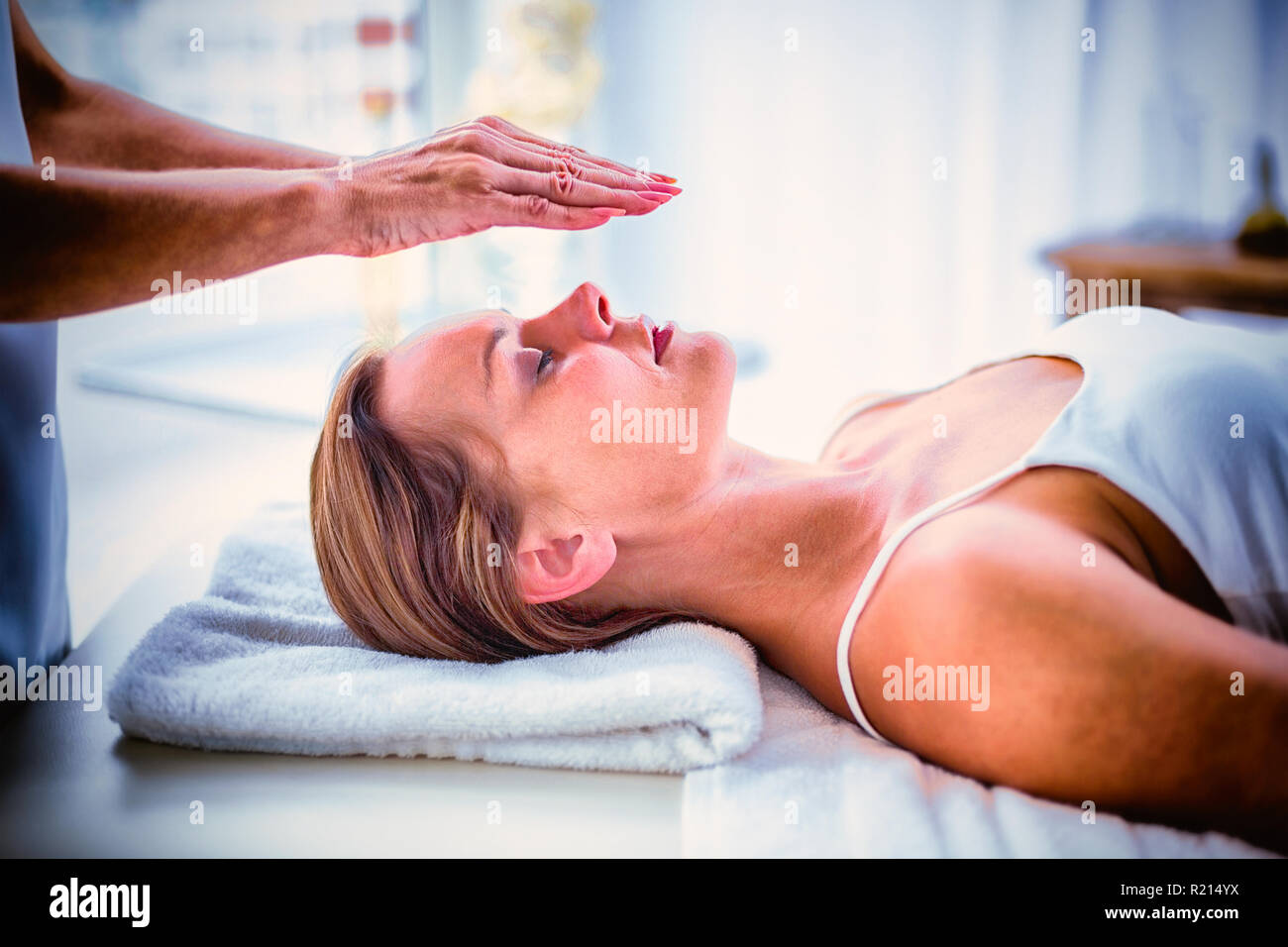 Cropped hands of therapist performing reiki on woman Stock Photo