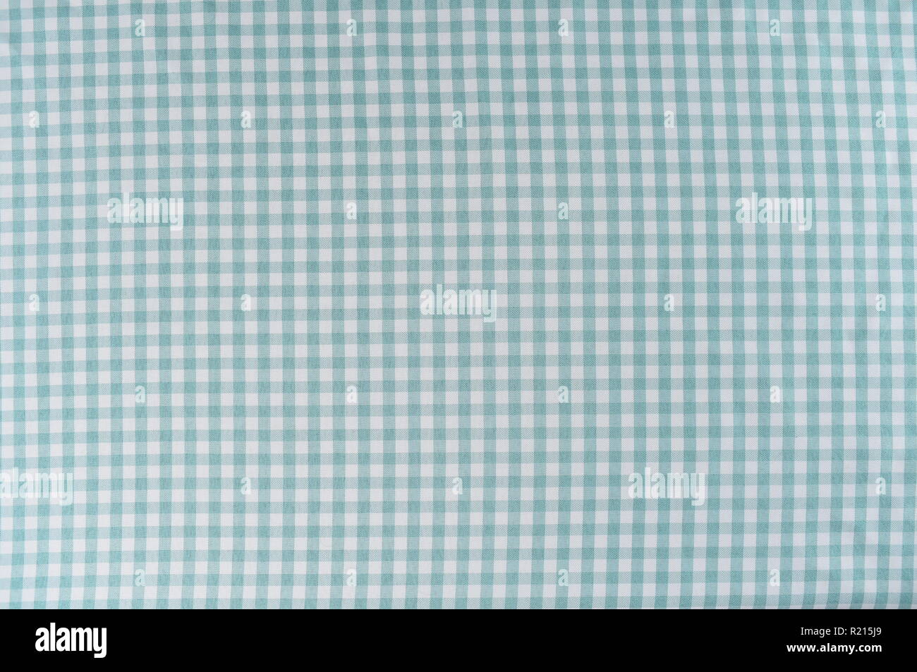 Mint and white is the checkered pattern on a tablecloth. The fabric is woven and is wrinkle free. Stock Photo