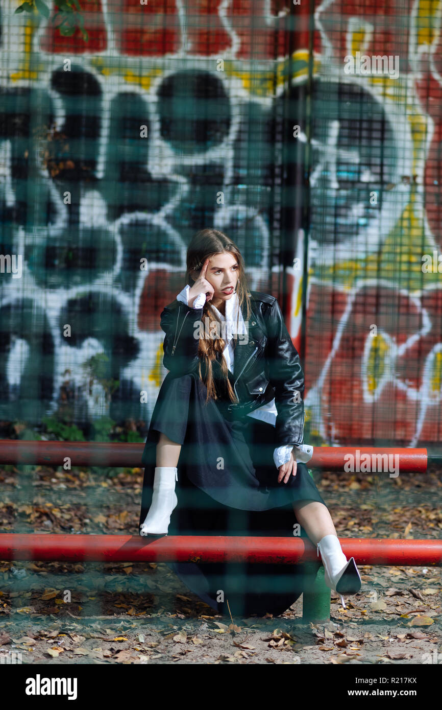 Trendy skinny model wearing fashionable outfit posing at the stadium Stock Photo