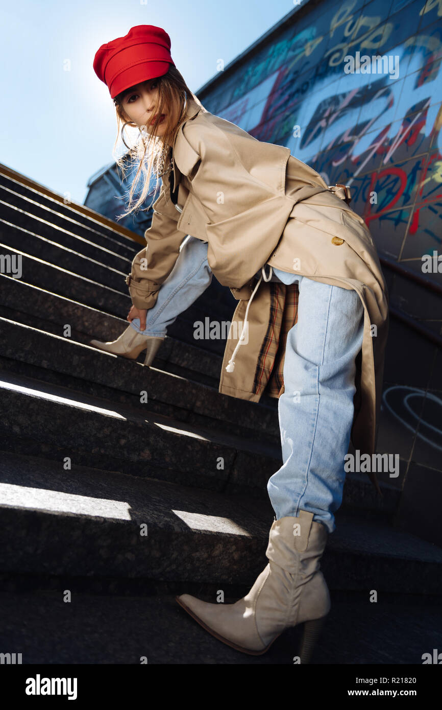 Dark-haired trendy model with bright lips wearing red beret and beige coat  Stock Photo - Alamy