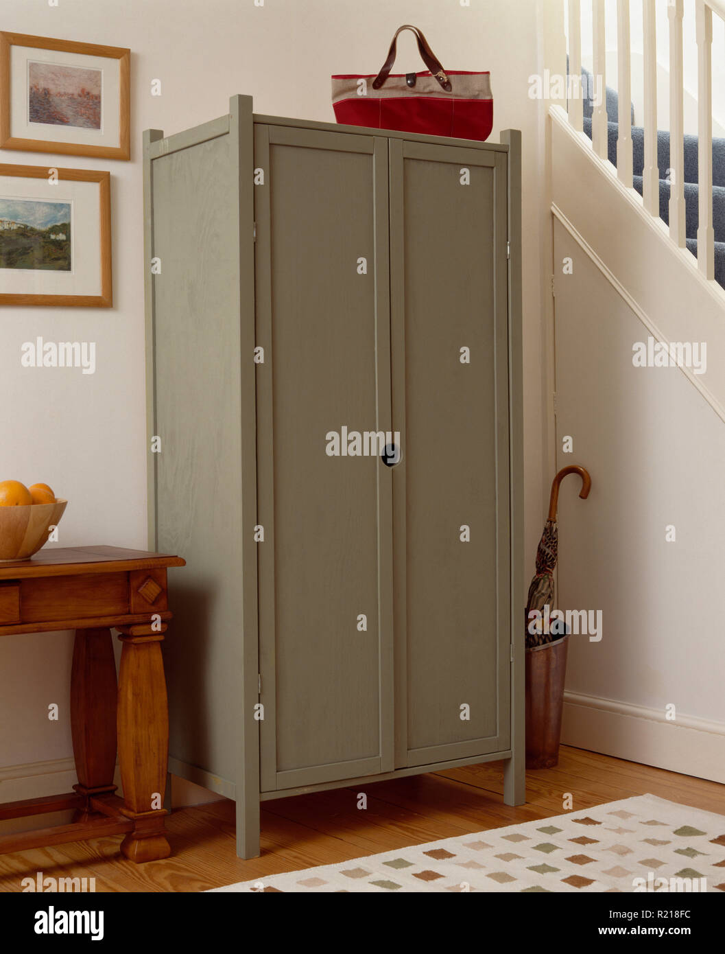 Pale grey painted cupboard in townhouse hall Stock Photo