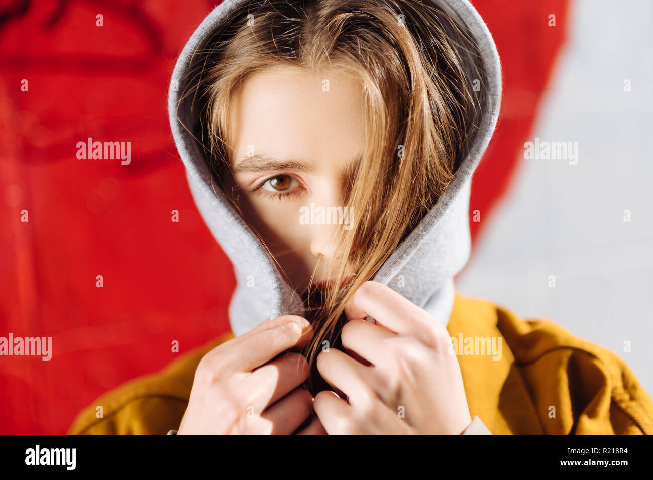 Close up of appealing model closing her face with hair and hoodie Stock Photo