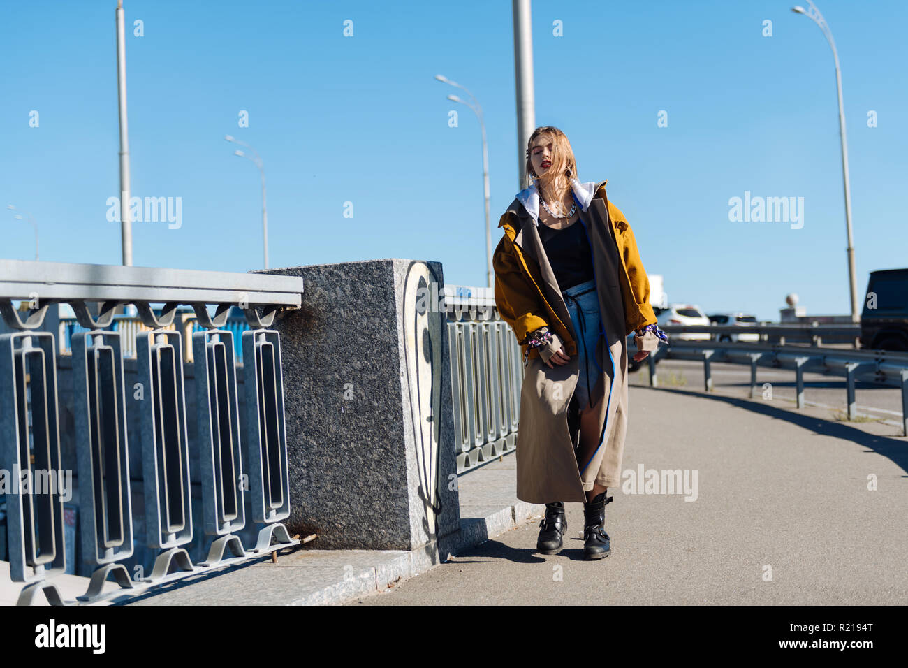 Beautiful young woman wearing oversize coat walking the bridge Stock ...