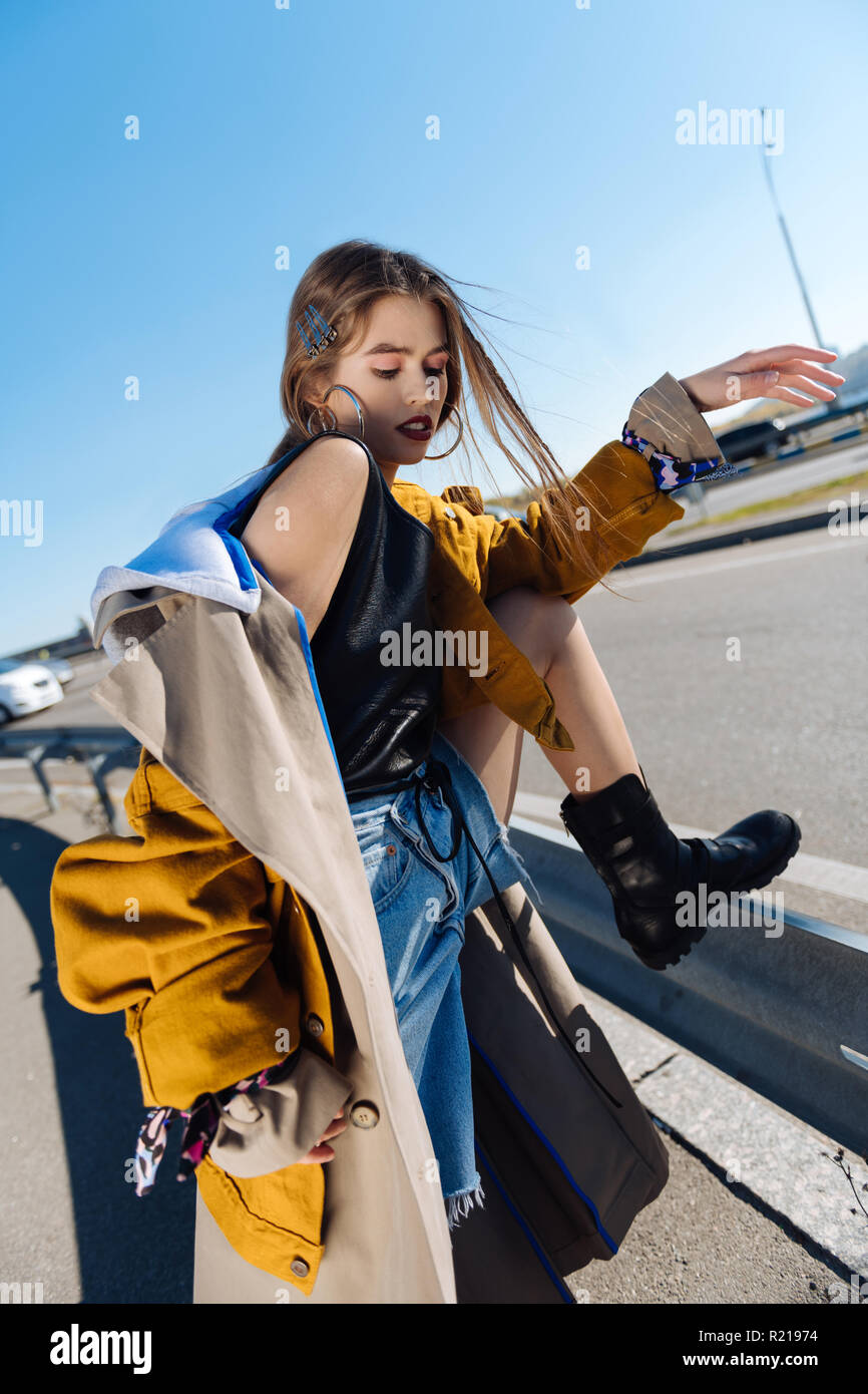 Dark-haired skinny model posing on the bridge on windy day Stock Photo