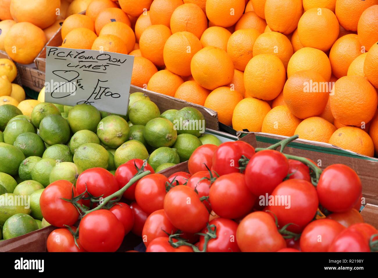 Oranges, limes and tomatoes at a marketplace in United Kingdom. Farmers market. Stock Photo