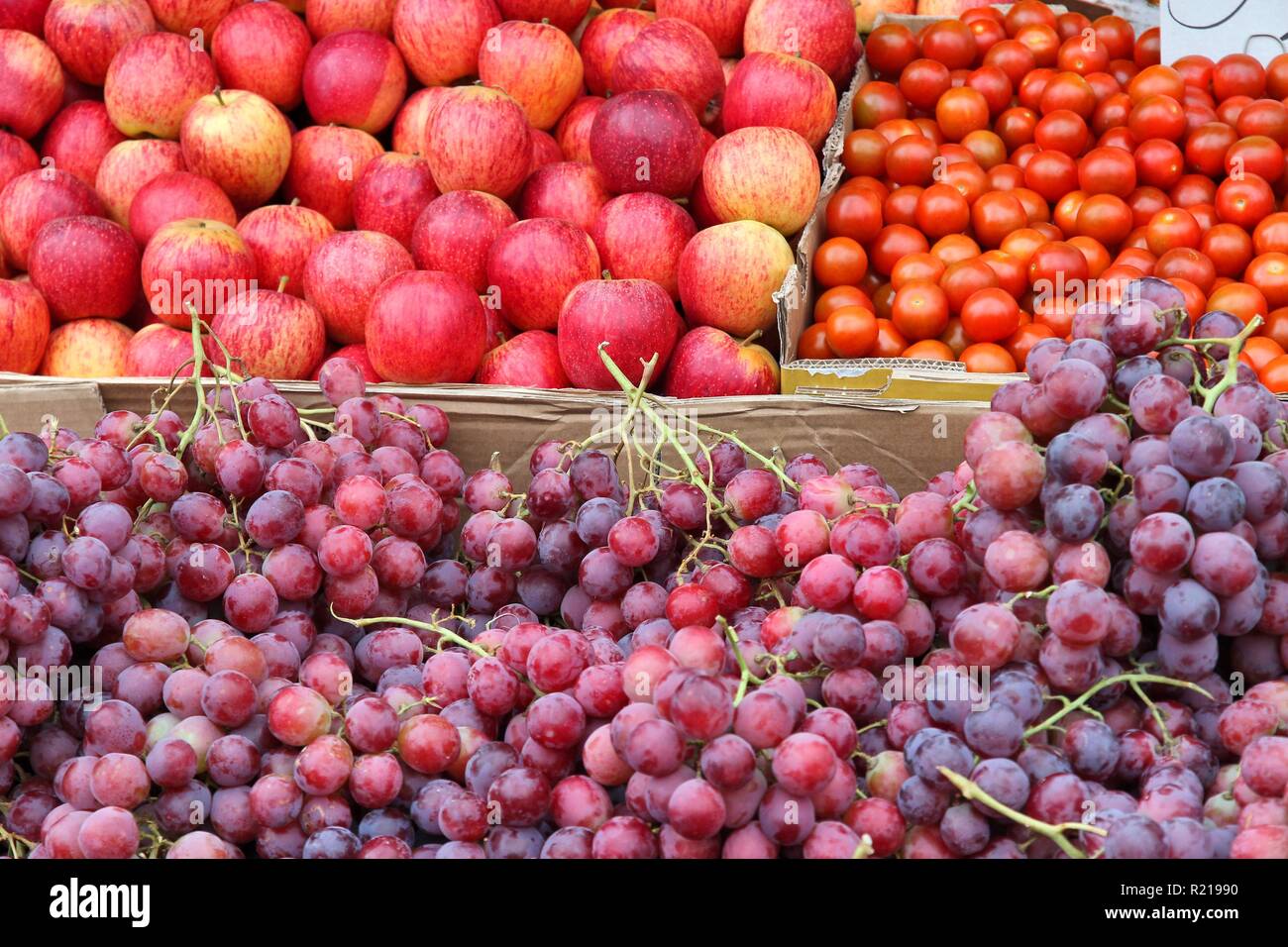 Apples, tomatoes and red grapes at a marketplace in United Kingdom. Farmers market. Stock Photo