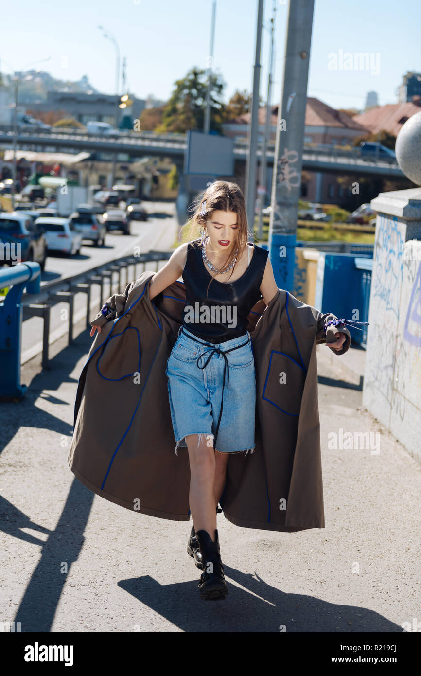 Stylish fashion blogger wearing denim shorts and baggy coat Stock Photo -  Alamy