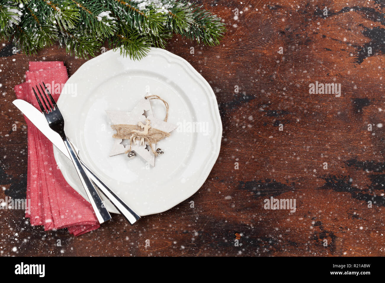Christmas table setting with fir tree branch covered by snow on wooden ...