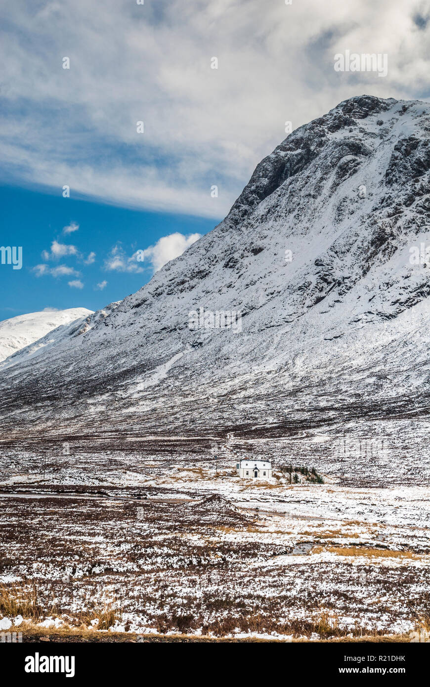 A lonely house under snowcapped mountains in the Pass of Glencoe (Glen Coe) in the Scottish Highlands Stock Photo