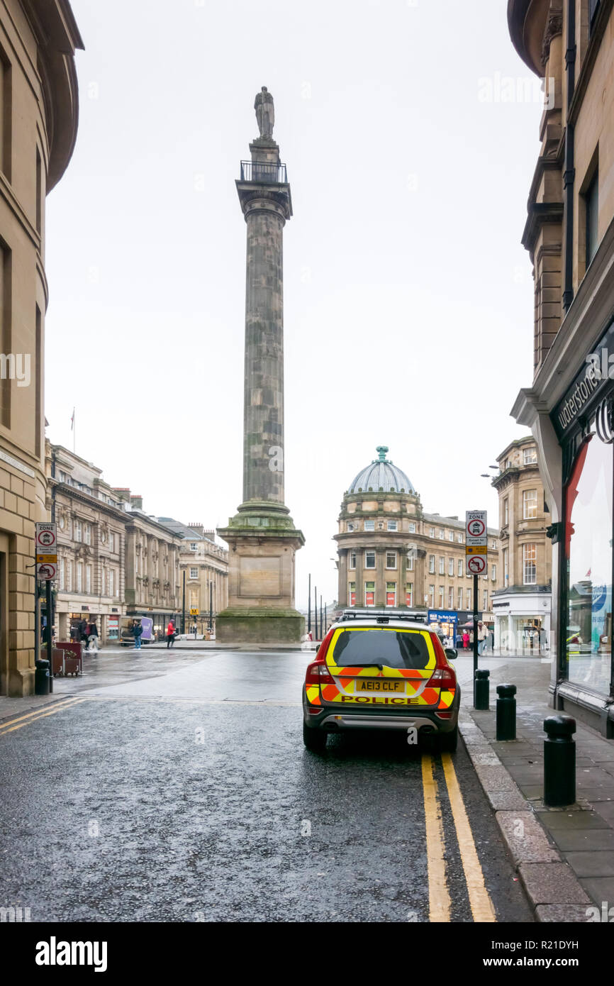A police car parked in a side street near Greys Monument, a column with statue on top, in the town centre of Newcastle upon Tyne, Tyne and Wear, UK Stock Photo