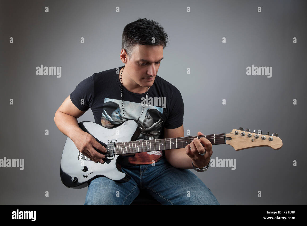 handsome man playing the guitar in a studio Stock Photo