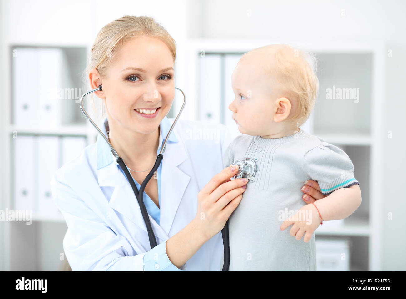 Doctor and patient in hospital. Little girl is being examined by pediatrician with stethoscope. Medicine and health care Stock Photo