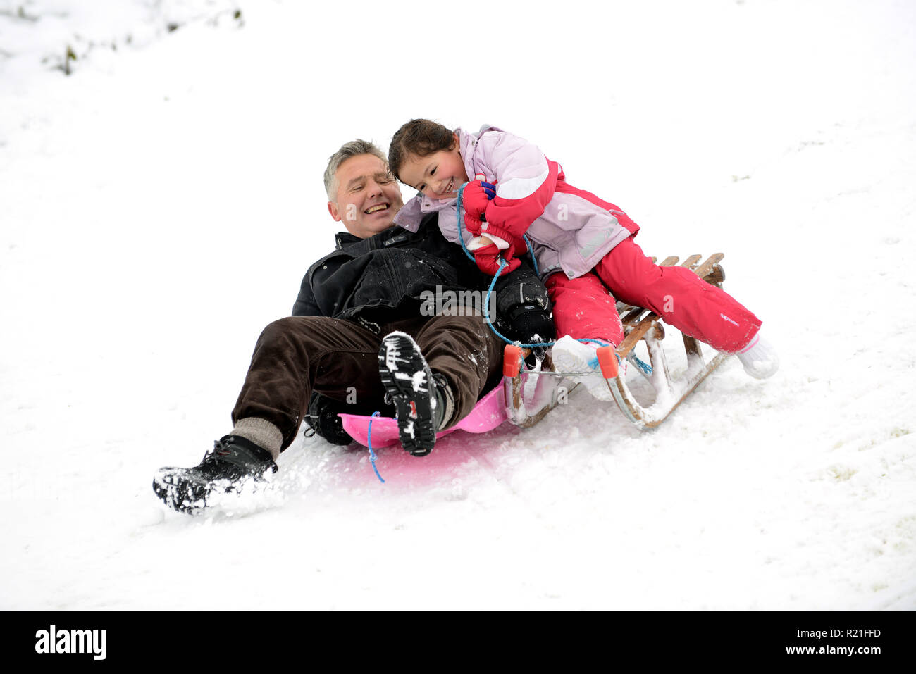 Father and daughter sledging in Shropshire Stock Photo