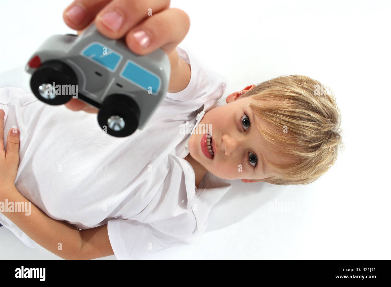 Adorable little boy playing with a small wooden car toy Stock Photo